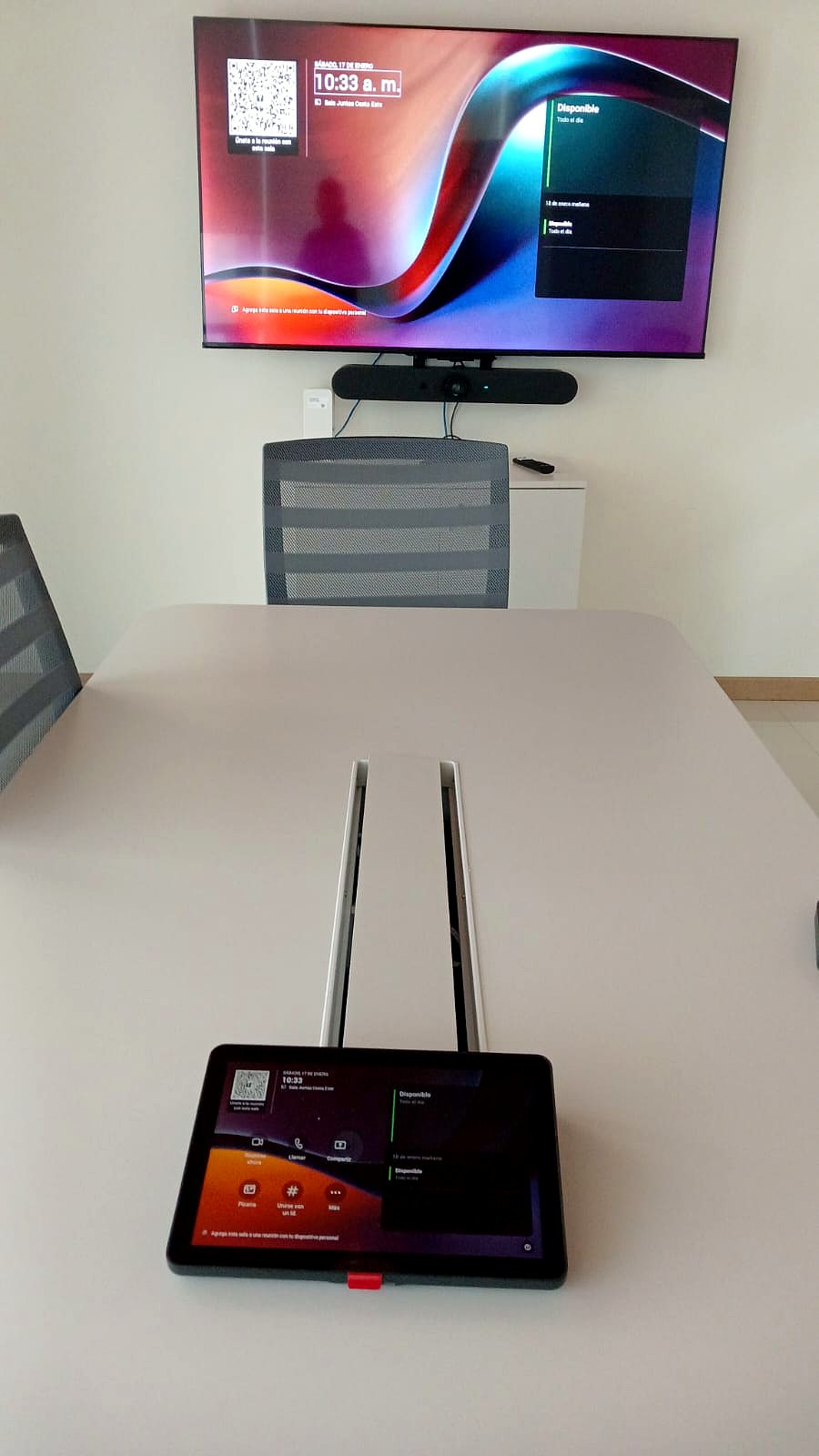 Sala de videoconferencia con barra de video y panel táctil